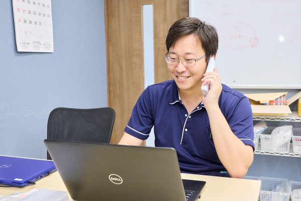 優しい笑顔で利用者さんからの電話に対応する安田さん